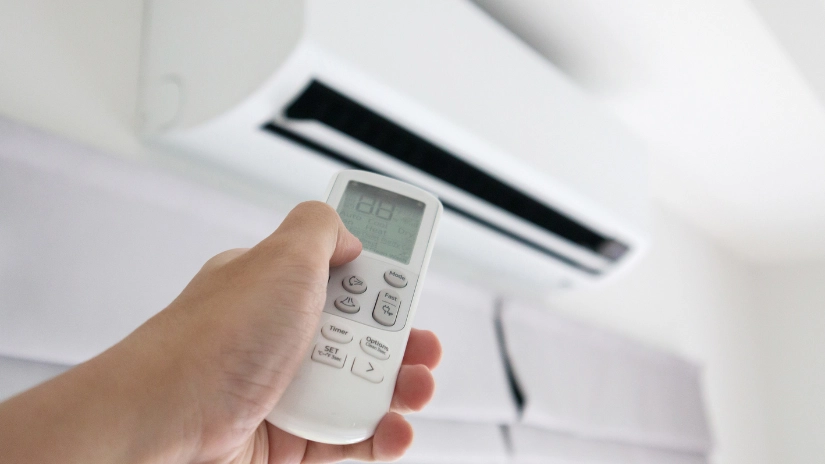 hand holding remote pointing at aircon after installation by Coyco