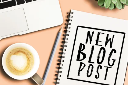 Desk with coffee, laptop, writing pad with words new blog post