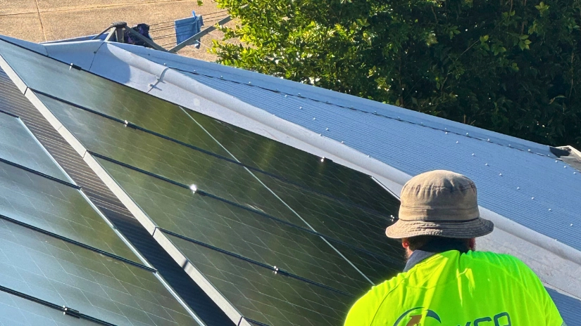 Coyco electrician on roof doing solar installation of panels