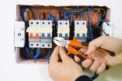 Coyco Rockingham Electrician hands holding wire cutter while working on electrical board with rcds
