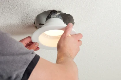 Hands of electrician installing LED light into ceiling for COYCO electrical