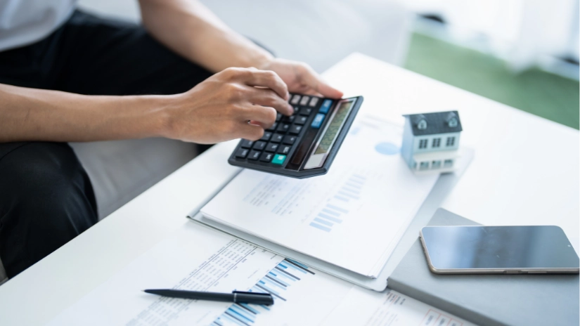 hands holding calculator looking at power bills for solar savings