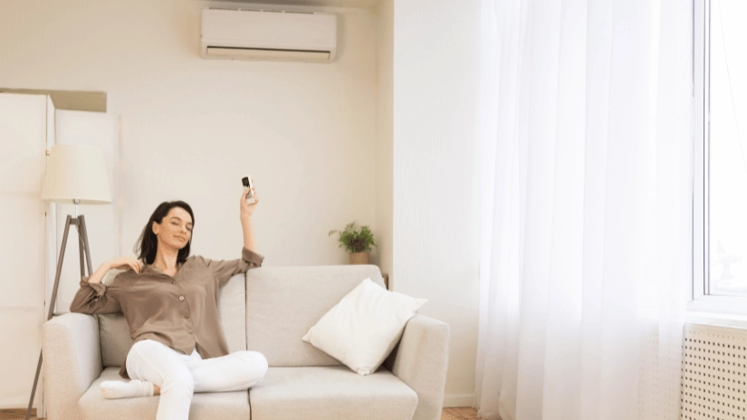 Woman sitting in comfort in lounge with split system air conditioning working